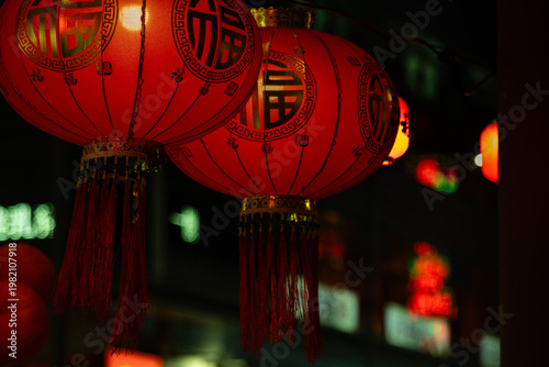 Close-up of red Chinese lanterns decorated with gold fortune characters and tassels, hanging at night at Temple Street Night Market, Kowloon, Hong Kong