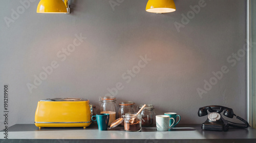Modern kitchen counter with a bright yellow toaster, coffee jars, colorful mugs, and a vintage black telephone.