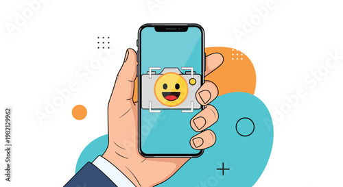 Hand holding a modern smartphone capturing a photo of a happy yellow emoji face through the camera interface with colorful background.