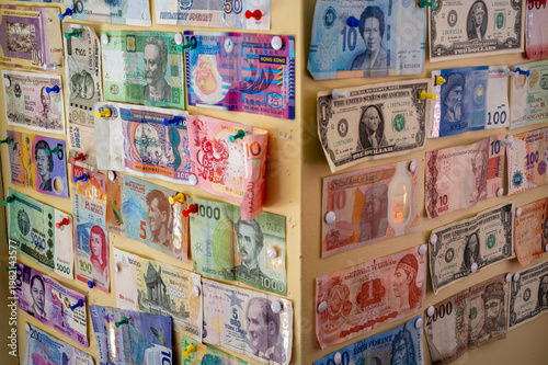 International banknotes pinned on wall