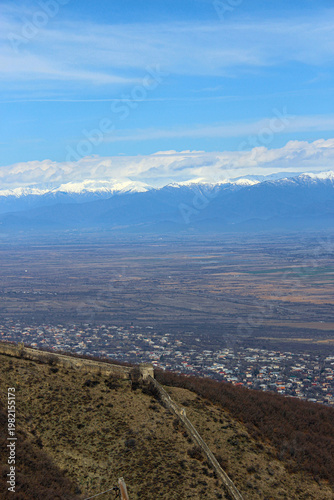 Aerial view of the old city's fortress wall. The village, the Alazani Valley, the Caucasus Range, and snow-capped mountains in the background. Sighnaghi, Kakheti, Georgia