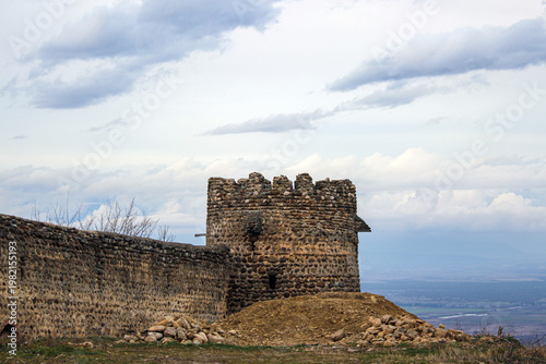 Fortress wall, defensive tower of the old city. Alazani Valley, Caucasus Mountains in the background. Sighnaghi, Kakheti, Georgia