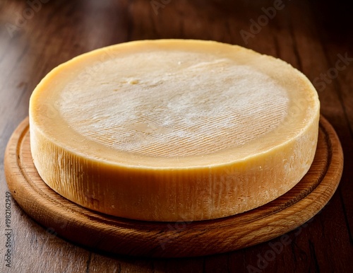 hard cheese wheel on wooden plate