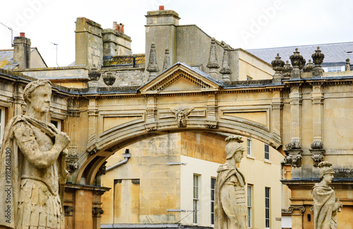 Stone statues of Roman warriors in Roman Baths complex in Bath, Somerset, England, UK. City of Bath  is a UNESCO World Heritage Site. Selective photo on arch.