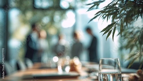 A blurred scene depicts a business meeting with a glass of water in the foreground.