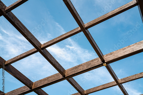 Wooden Roof Frame Structure Against Blue Sky Background