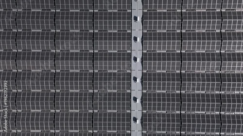 Top-down ascending view of floating solar farm on a lake