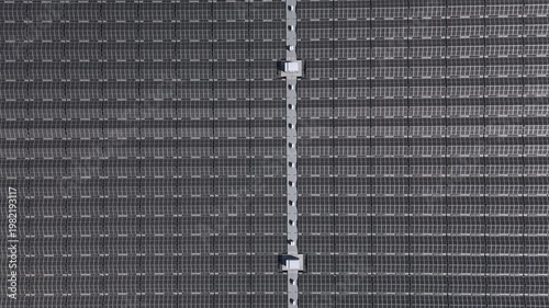 Top-down descending view of floating solar farm on a lake