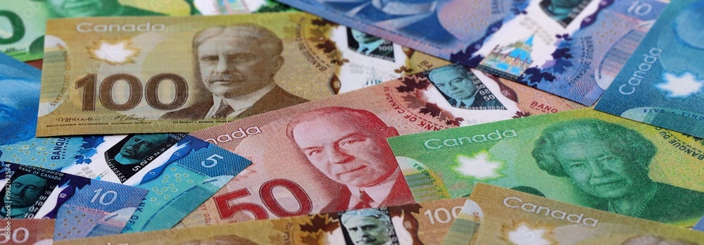 Fototapeta premium Canadian dollar money bills pile on table. Canada banknotes of CAD currency close up.