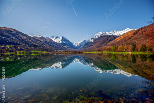 Photography Lake Génos Loudenvielle, France, with the Pyrenees mountains reflected in its wa