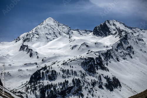 Photography Snow-capped peaks of the French Pyrenees in the town of Génos, France, on a sunn