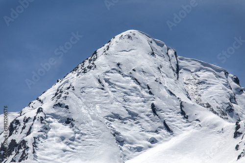 Fotografi Snow-capped peaks of the French Pyrenees in the town of Génos, France, on a sunn