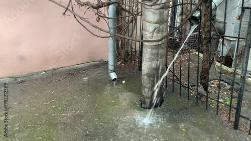 Rainwater flows down drainpipes during a downpour in the old town.