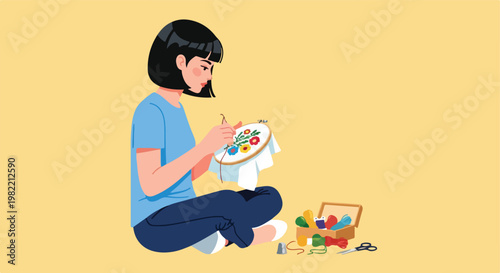 Woman with black bob hair sewing floral patterns into hoop sitting on the floor