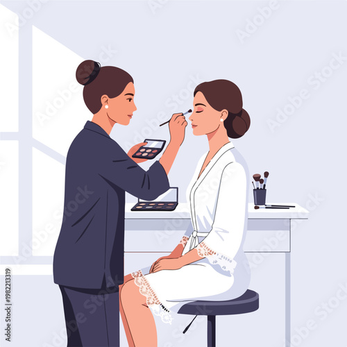 Makeup artist applying eyeshadow to a young bride in her white bridal lace robe