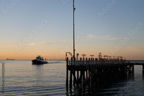 Ocean Pier with Small Boat on the Horizon