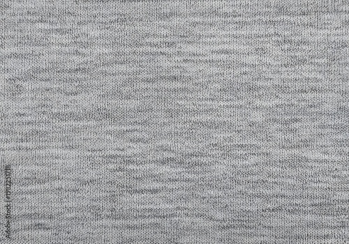 Detailed close up of a grey marl knitted fabric texture with visible stitches and fibers