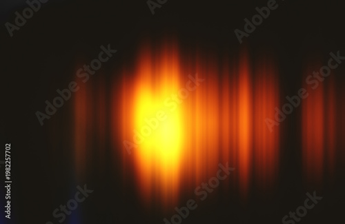 Vibrant streaks of orange and yellow light blending against a dark backdrop, forming an energetic flow and radiant aura