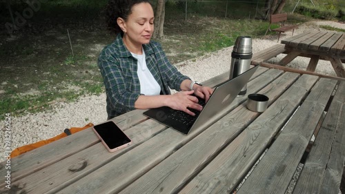 Woman Working Remotely on Laptop at Outdoor Picnic Table