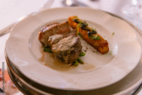 Gourmet plated steak with creamy sauce and roasted vegetables in fine dining restaurant