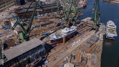 Aerial View of Shipyard with Vessels Under Construction and Large Gantry Cranes at Industrial Port Editorial Use