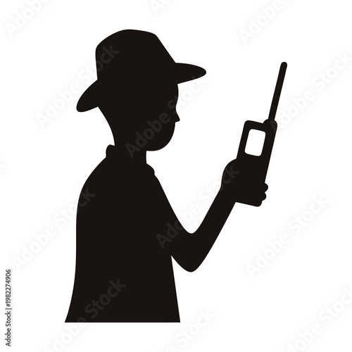 Silhouette of a person wearing hat and holding a walkie talkie