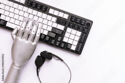 Artificial intelligence concept. Metal robotic hand working with lap top keyboard on white background top view. Copy space for your design. New technologies in bussines and education.