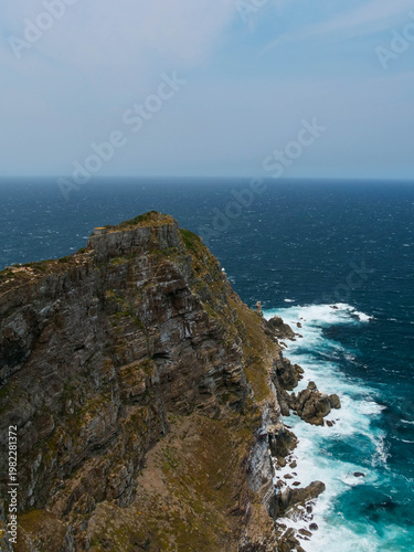 Rugged rocks,  sheer cliffs towering above the beach and ocean at Cape Point, part of Table Mountain National park, Cape Town, South Africa, a popular tourist or travel destination. Vertical image