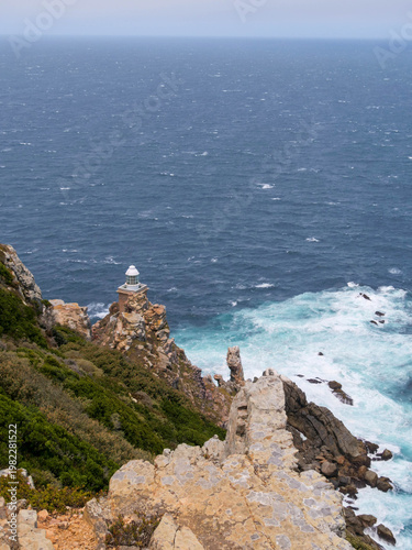 The new white lighthouse located on the edge or point at Cape Point, part of Table Mountain National Park, Cape Town, South Africa, a popular tourist and travel destination. Vertical image
