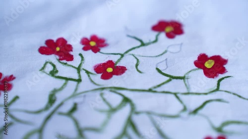 Traditional Bangladeshi hand-painted fabric on a child girl’s white gown with colorful folk art patterns, vibrant textile details, cultural fashion design, and artistic dress decoration.