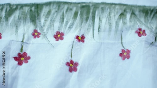 Traditional Bangladeshi hand-painted fabric on a child girl’s white gown with colorful folk art patterns, vibrant textile details, cultural fashion design, and artistic dress decoration.
