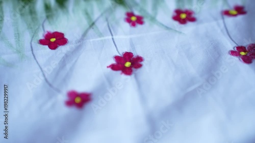 Traditional Bangladeshi hand-painted fabric on a child girl’s white gown with colorful folk art patterns, vibrant textile details, cultural fashion design, and artistic dress decoration.