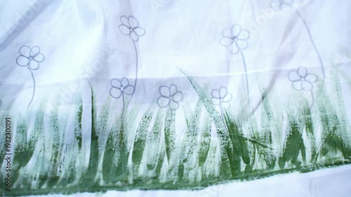 Traditional Bangladeshi hand-painted fabric on a child girl’s white gown with colorful folk art patterns, vibrant textile details, cultural fashion design, and artistic dress decoration.