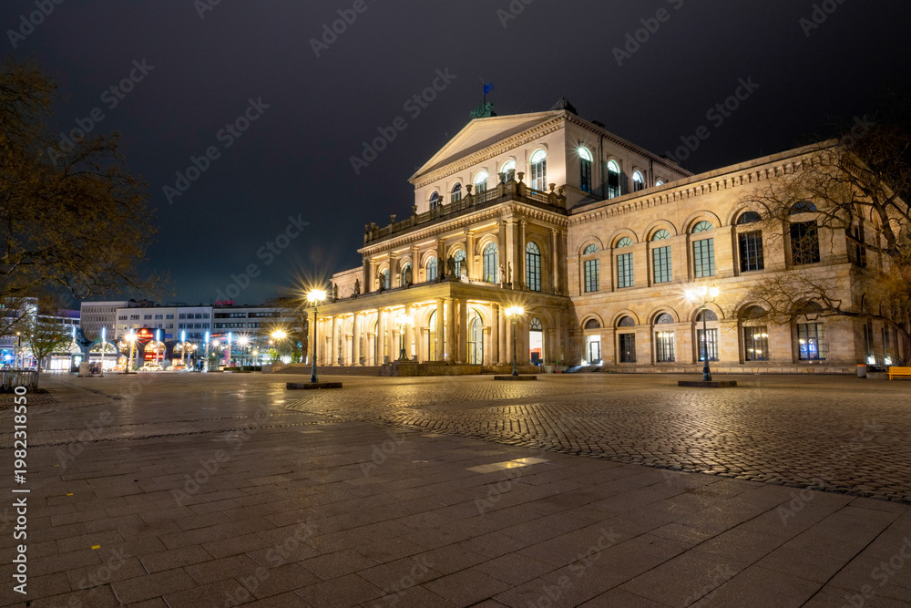 Fototapeta premium Abendstimmung am Opernplatz in Hannover mit beleuchtetem Opernhaus.