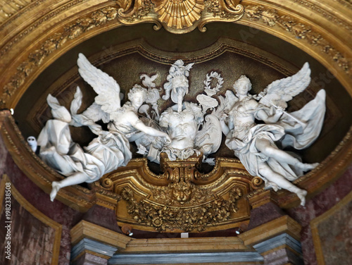 Sculture in marmo bianco raffiguranti angeli alati in stile barocco all'interno di una nicchia monumentale con decorazioni e rilievi dorati
