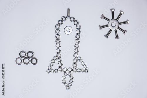 An artistic composition using nuts, washers, and bolts to form a rocket that has already been launched. The central structure is elongated and symmetrical, with a base that suggests propulsion. 