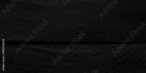 Ebony black charred wood texture background with horizontal grain detail, dark carbonized timber surface for backdrop