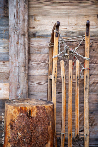 Old Fashioned Wooden Sled And Tree Stump Against Wood Background