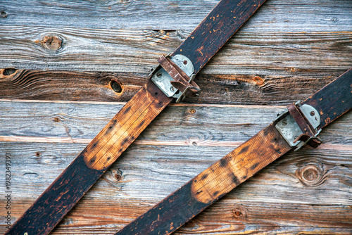 Detail Of Antique Wooden Skis With Leather Bindings On Timber Wall