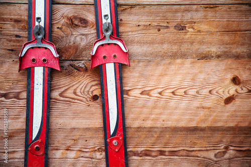 Close Up Of Vintage Red Skis Mounted On Rustic Wooden Wall