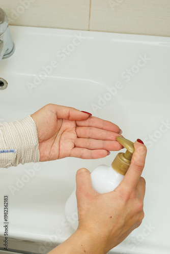 Woman washing hands in bathroom sink, hygiene routine