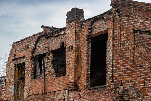 Abandoned Brick Factory Facade with Crumbling Walls and Empty Windows