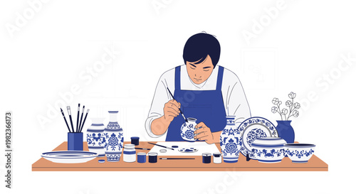 A focused man in a blue apron is meticulously painting a small ceramic vase with a brush at a table filled with pottery items.