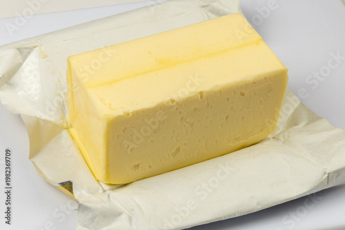 A pound of butter on it open wrapper ready for baking isolated on white