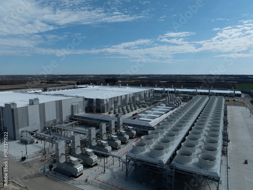 Foto Aerial view of a large AI data center with industrial cooling systems, servers, and infrastructure in a modern high-tech facility under a clear blue sky