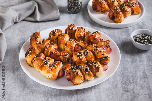 Homemade sausages in sesame dough on a plate on the table