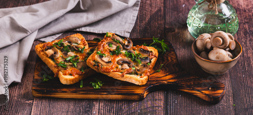 Delicious baked sandwiches with cheese, mushrooms and herbs on a board web banner