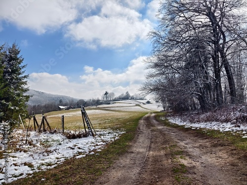landscape with a dusty road and remnants of snow