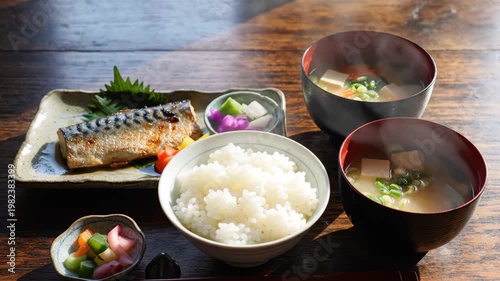Delicious japanese meal with grilled fish and steaming bowls