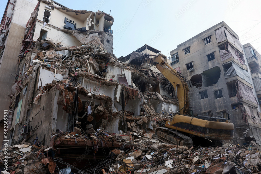 Fototapeta premium Southern Suburbs - April 10 2026: Heavy machinery work at the site of an Israeli strike carried out in southern suburbs of Beirut Lebanon showing excavation equipment clearing rubble and debris
